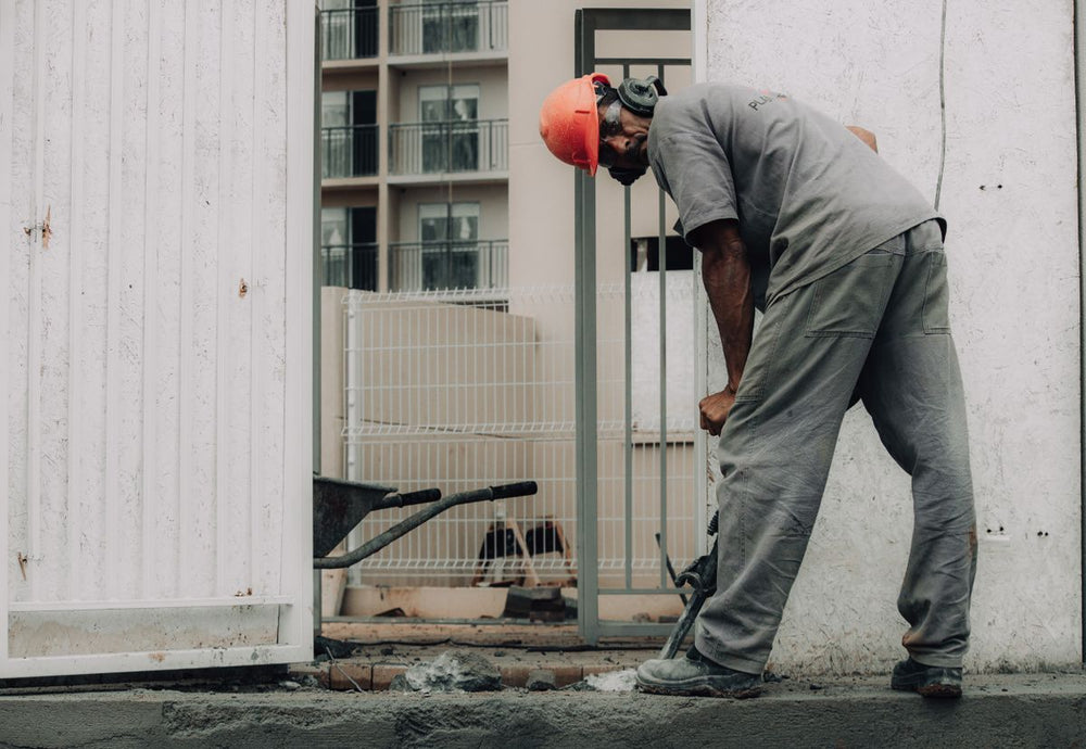 Worker operating a jackhammer on a construction site