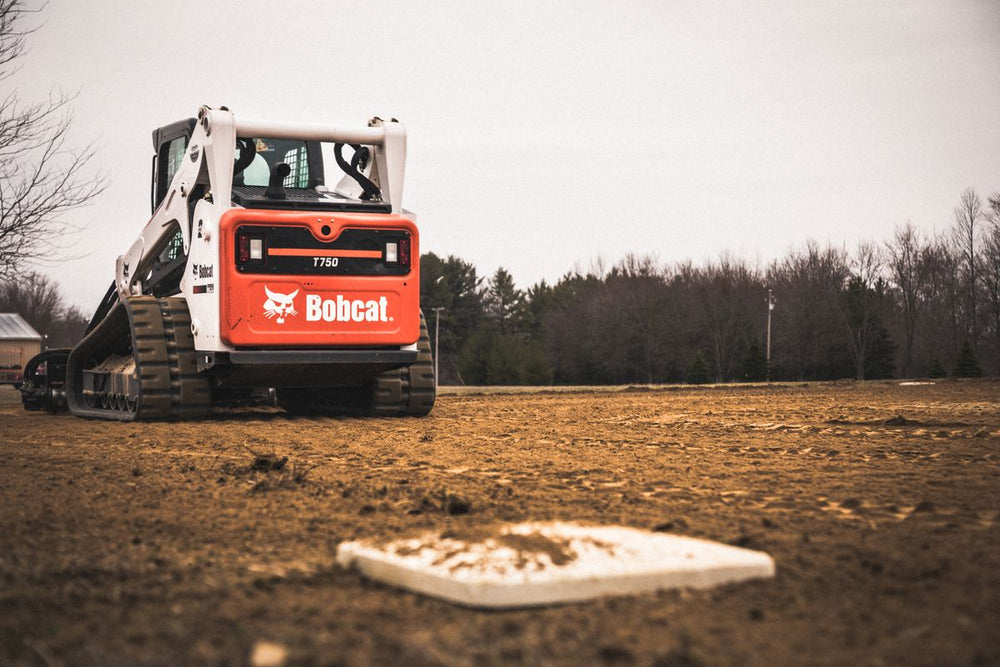 Compact track loader on a dirt field