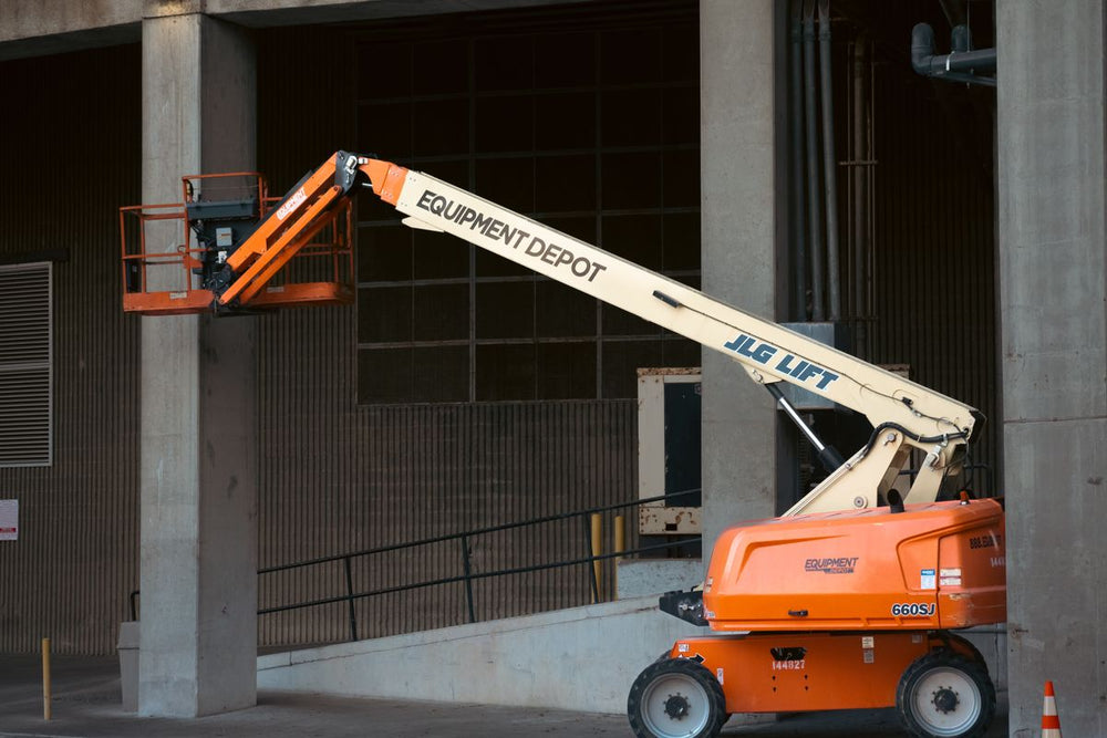 Orange telescopic boom lift at an industrial site