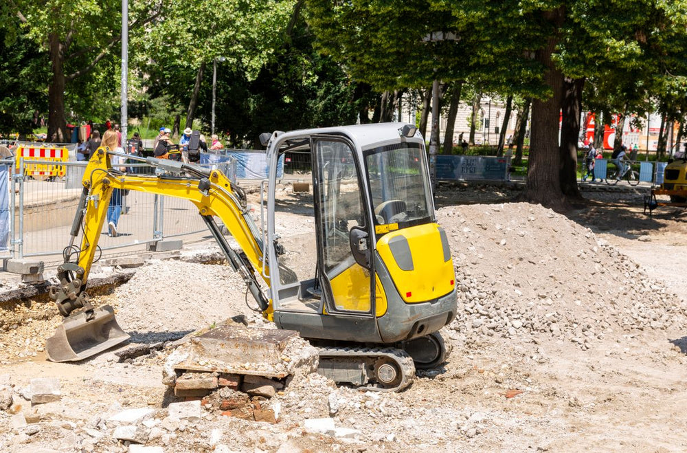 Yellow mini excavator digging at a construction site
